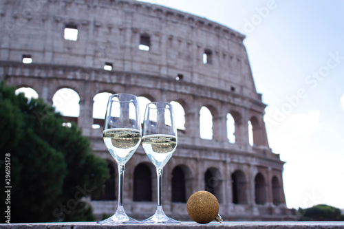 Canvas Print Celebration theme with two glasses of champagne and gold Christmas ball are on the background of the Colosseum