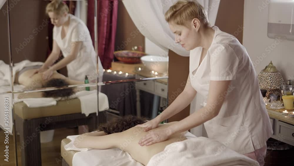 Professional female masseur doing massage for client at spa salon, healthcare Professional female masseur doing massage for client at spa salon, healthcare