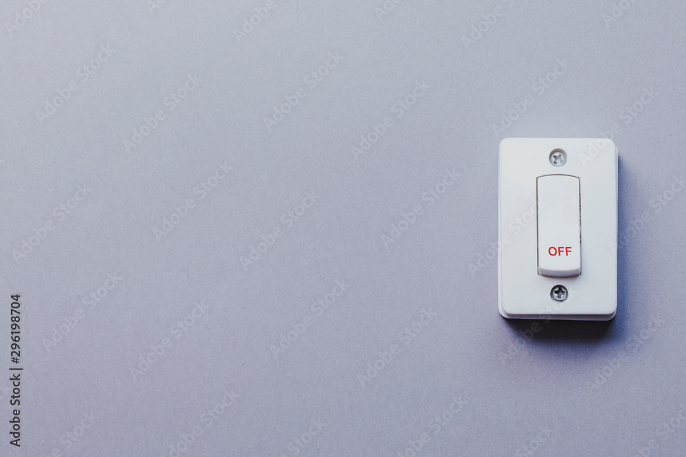 Light switch on grey wall. On and Off switch. Saving energy concept Light switch on grey wall. On and Off switch. Saving energy concept