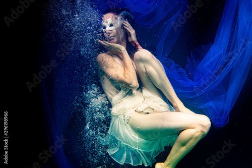 model, half naked under water posing with bubbles and blue fabric