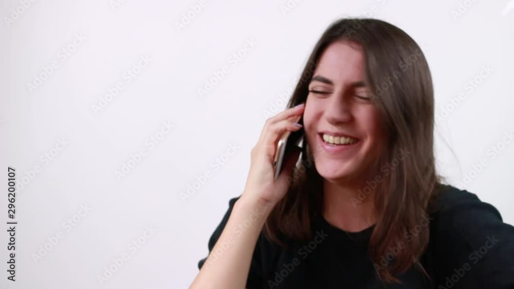 Dark-haired girl talking on the phone. White background.Girl with dark brown hair. Dark-haired girl talking on the phone. White background.Girl with dark brown hair.