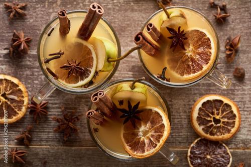 top view of seasonal pear mulled wine cocktails with spices and dried citrus on wooden rustic table