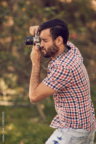 Photographer with beard and photographic camera outdoor.