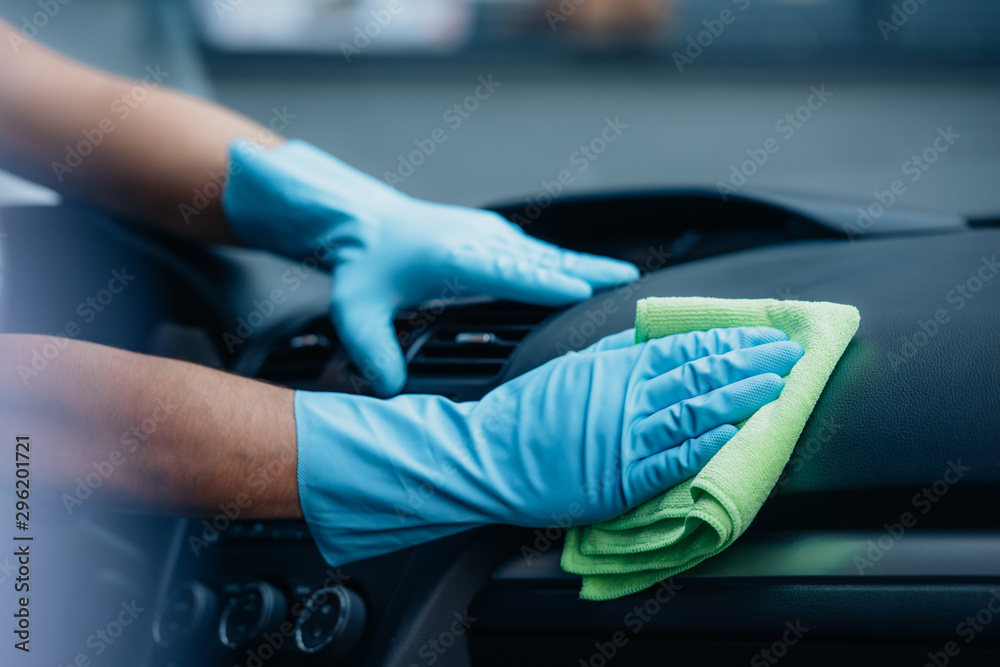 partial view of car cleaner vacuuming dashboard with rag partial view of car cleaner vacuuming dashboard with rag