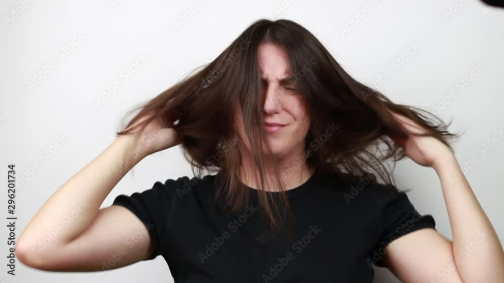 Brown-haired woman loose hair. Shakes her hair. White background Brown-haired woman loose hair. Shakes her hair. White background