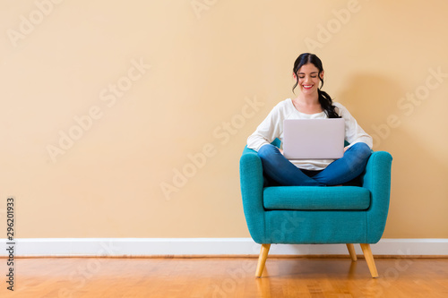 Young woman with a laptop computer sitting in a chair