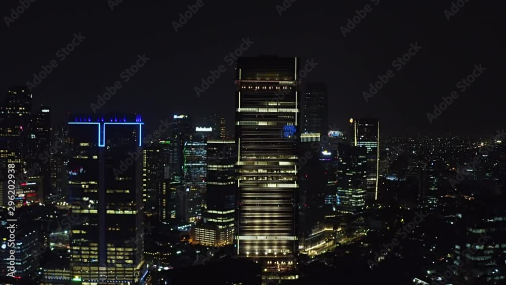 JAKARTA, Indonesia - October 07, 2019: Beautiful aerial view of modern skyscrapers exterior with night lights in financial district. Shot in 4k resolution from a drone flying forwards JAKARTA, Indonesia - October 07, 2019: Beautiful aerial view of modern skyscrapers exterior with night lights in financial district. Shot in 4k resolution from a drone flying forwards