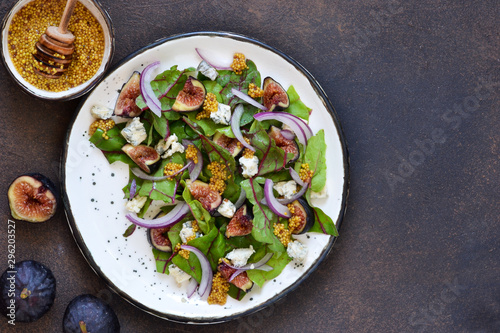 Vitamin salad with figs and blue cheese on a warm background.