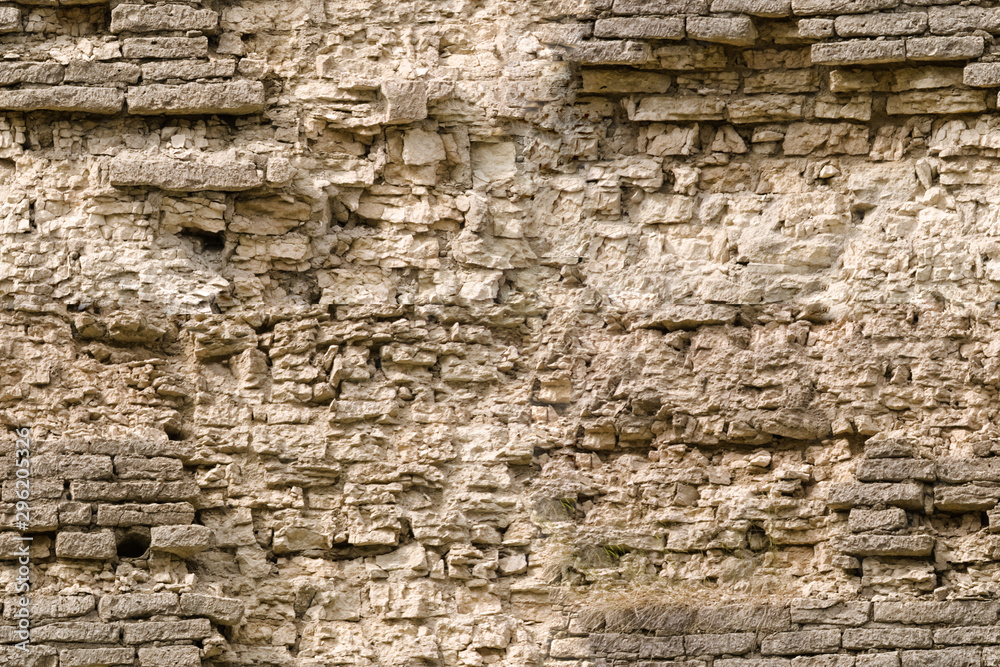 Seamless texture of a sandstone fortified wall with fragments of rectangular blocks of crumbling cladding. Seamless texture of a sandstone fortified wall with fragments of rectangular blocks of crumbling cladding.