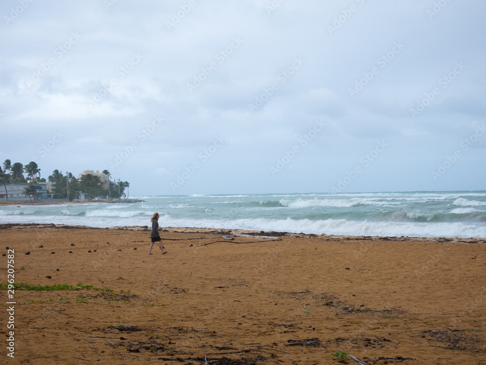 Girl walking by the sea before the storm, Luquillo, Puerto Rico