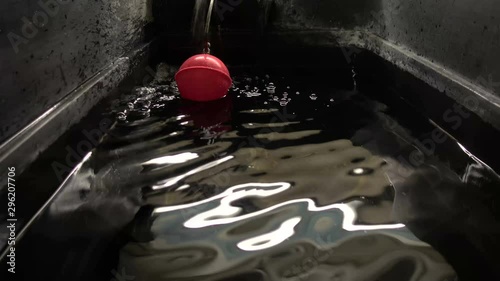 Ripples and bubbles inside a cold water storage tank as it fills up photo