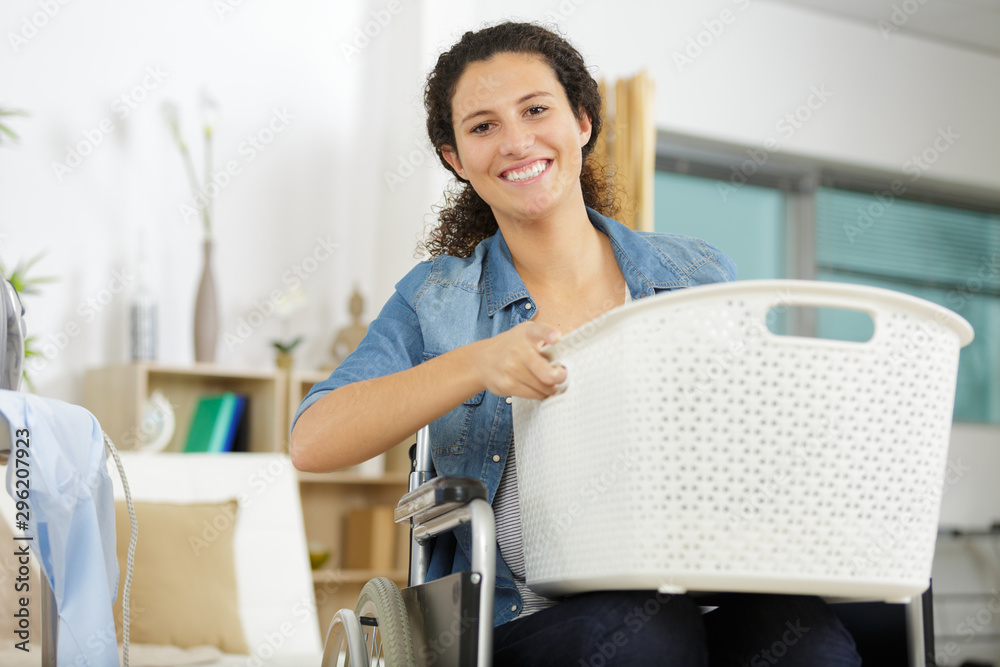 young woman on the wheelchair with laundry basket