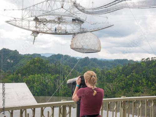 Woman watching the installation of Arecibo observatory with the help of Old Binoculars. Puerto Rico, USA. photo