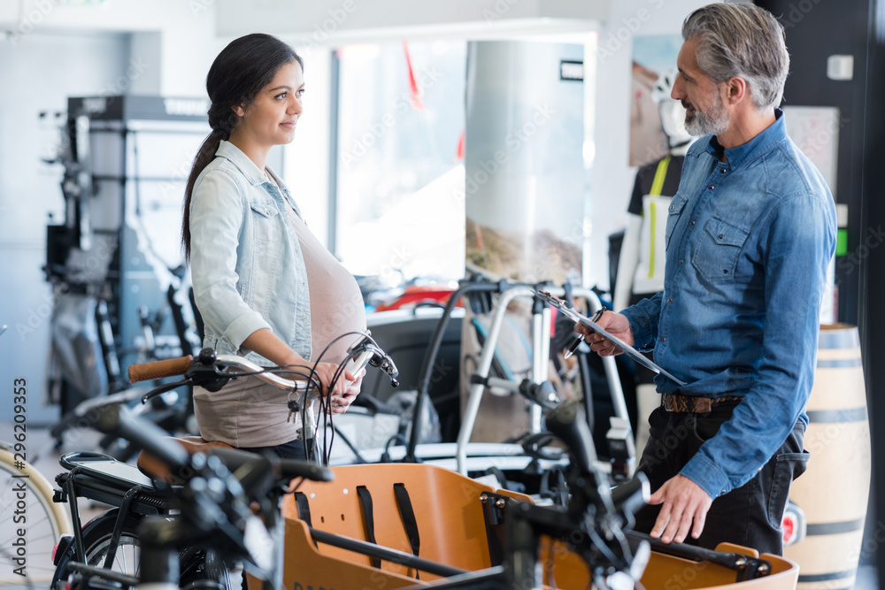 pregnant lady looking at bicycle trailer