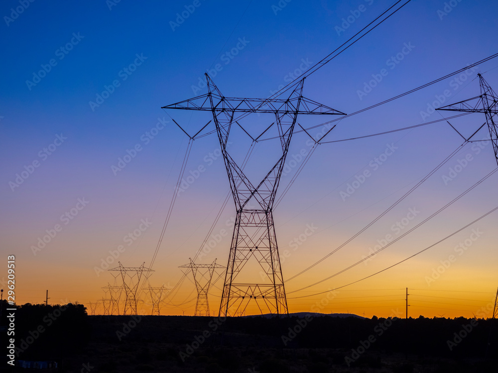 Silhouette High voltage electric towers at sunset time. High-voltage power lines. Electricity distribution station