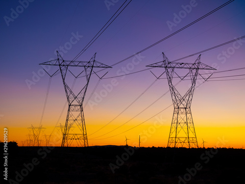 Silhouette High voltage electric towers at sunset time. High-voltage power lines. Electricity distribution station © Christian Delbert