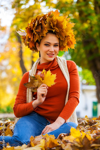 Happy woman with a wreath of maple leaves on her head