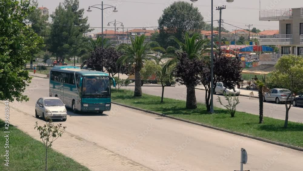 Traffic at Nea Poroi a summer vacation resort in Greece. Boulevard with palm trees Traffic at Nea Poroi a summer vacation resort in Greece. Boulevard with palm trees
