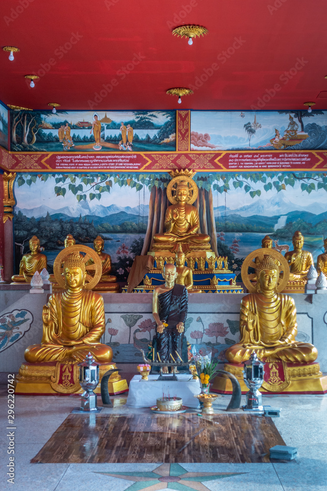 Bang Saen, Thailand - March 16, 2019: Wang Saensuk Buddhist Monastery. Center closeup of Golden statues in main open Prayer Hall with in center statue of founder of abbey. 