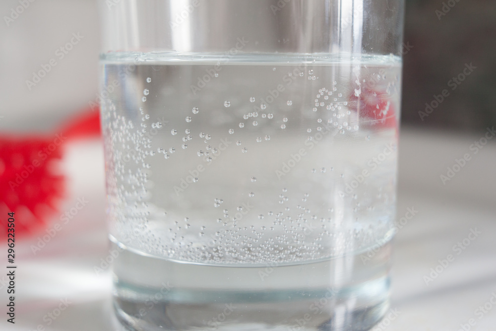 A glass of city tap water with air bubbles stuck to the side of