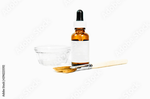 Blank drip bottle for cosmetic chemical peel formula, with dish and applicator makeup  brush, for beauty treatments, with white blank label. Room for text (copy). photo