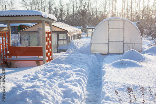 Plastic greenhouse in the winter garden. A lot of snow.