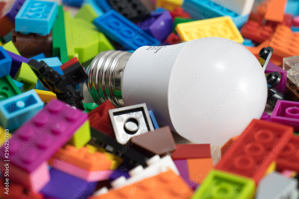 Light bulb in the middle of colorful toy bricks - obrazy, fototapety, plakaty 