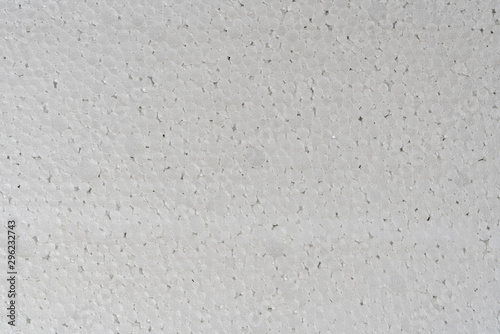 White abstract polystyrene foam background texture close-up detail view. Polystyrene, styrofoam, plastic sheet abstract synthetic packaging material.