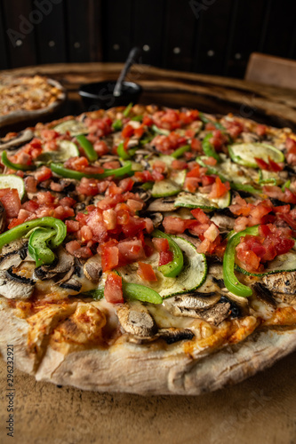 vista cercana de una deliciosa pizza de vegetales con jitomate, ajo, zuccini y hongos