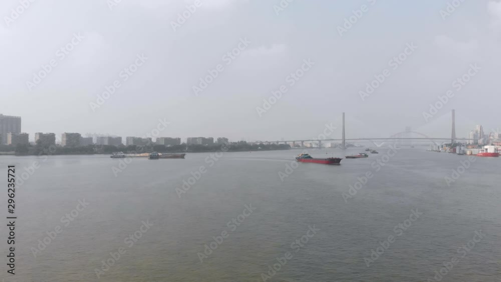 A drone flying in the city, a large number of cargo ships sailing along the river A drone flying in the city, a large number of cargo ships sailing along the river
