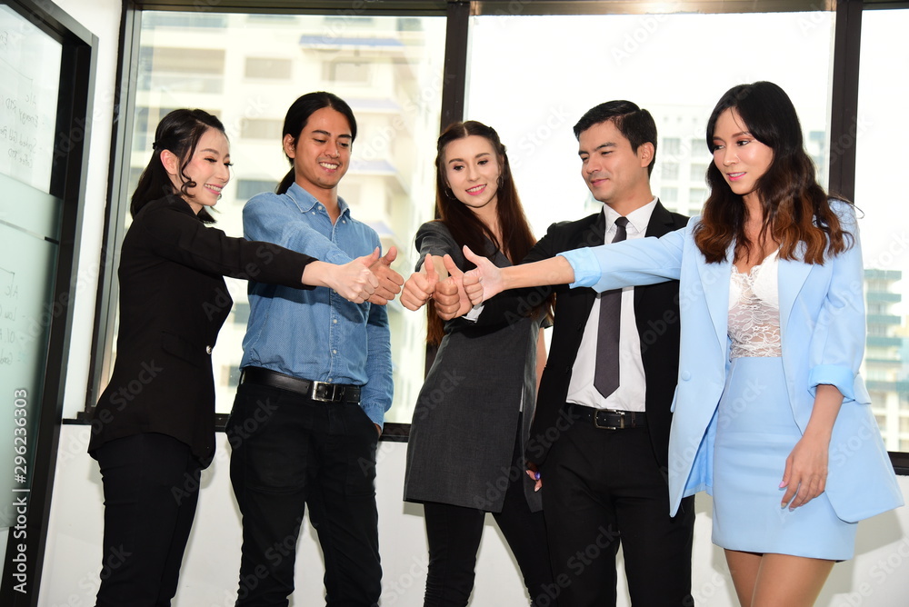 Business people in different ethnicities smiling and raising their thumbs for success in business and showing their support Business people in different ethnicities smiling and raising their thumbs for success in business and showing their support