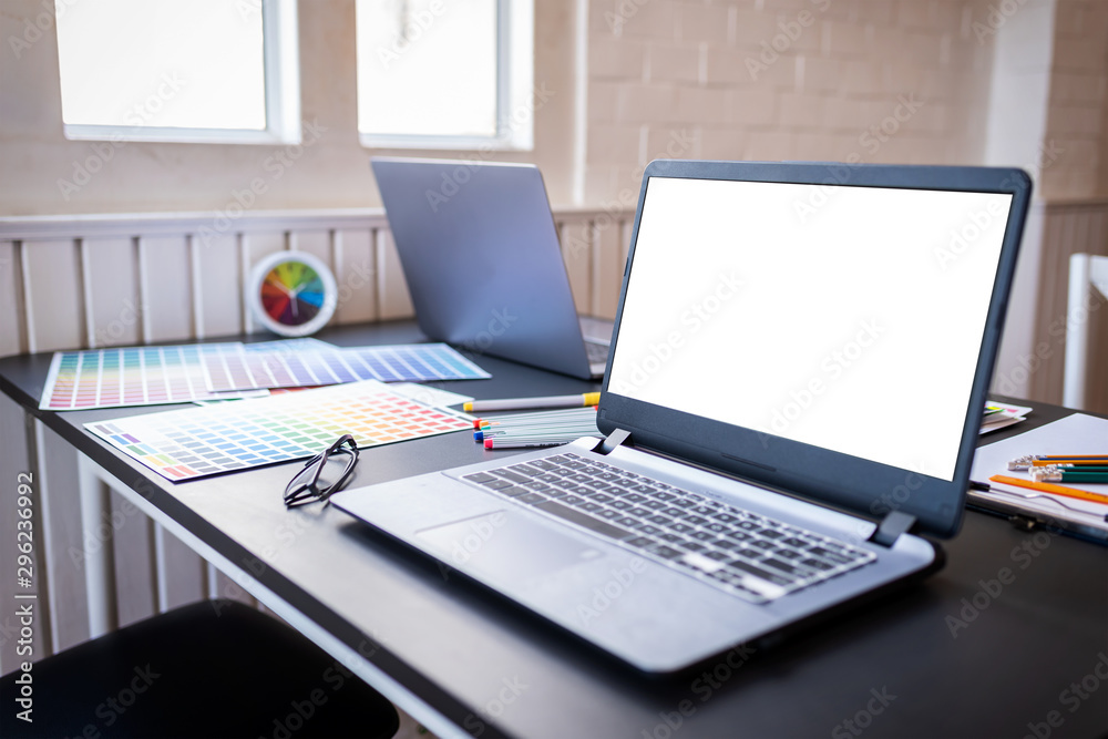Blank white laptop screen of graphic designers put on desk table in co-working space Blank white laptop screen of graphic designers put on desk table in co-working space