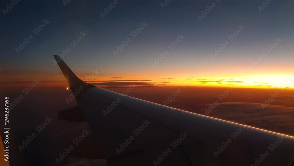 Beautiful orange sunset view from left airplane wing, turning right Beautiful orange sunset view from left airplane wing, turning right