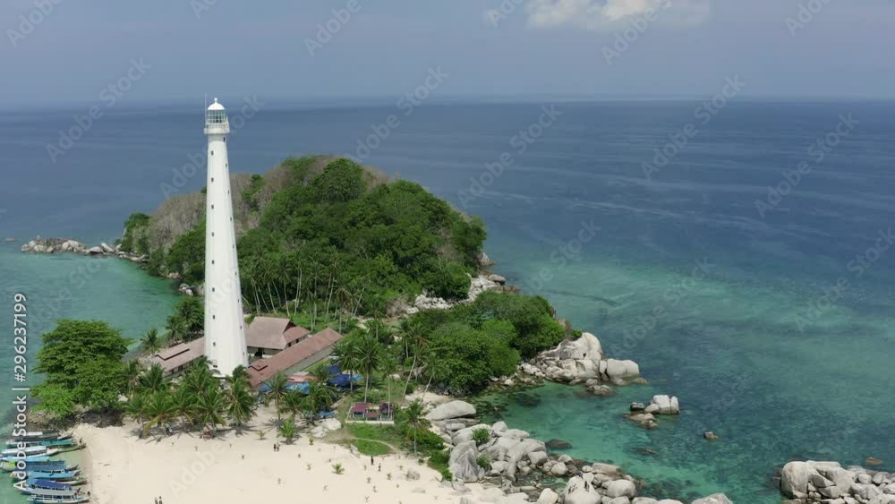 Aerial View of Light House at Lengkuas Island of Belitung Indonesia. Dramatic Tropical island with White Sandy beach and Trees. POI Point of Interest Drone Shot.Bird Eye View Aerial View of Light House at Lengkuas Island of Belitung Indonesia. Dramatic Tropical island with White Sandy beach and Trees. POI Point of Interest Drone Shot.Bird Eye View