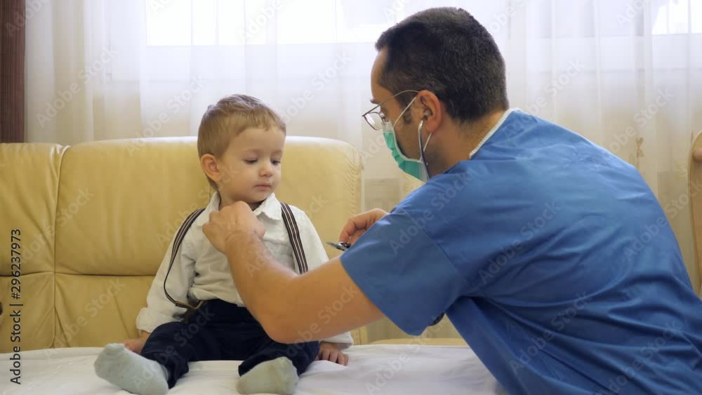 Doctor with mask and uniform consulting little child with stethoscope