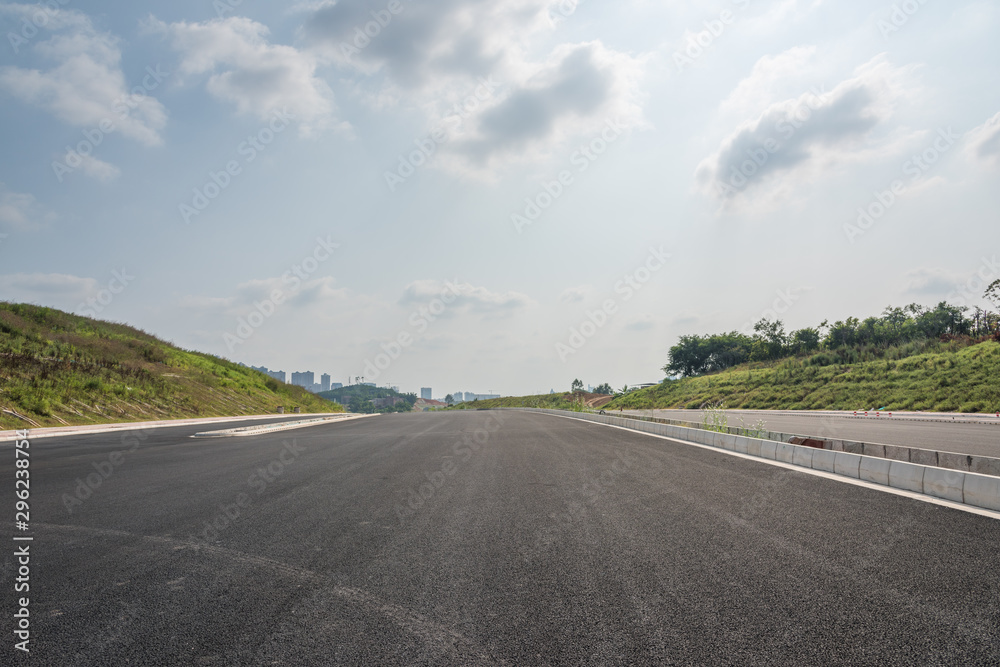 Perspective view of new asphalt road and sky in modern city suburb