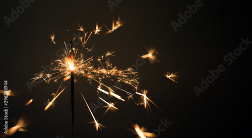 burning sparkler on dark background.