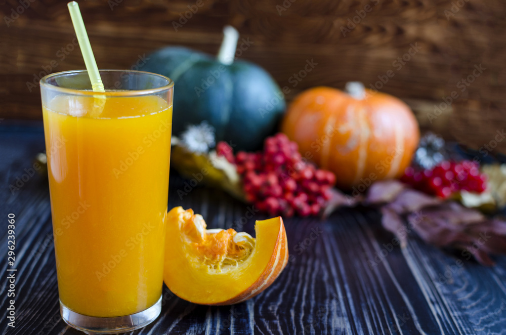 a glass of pumpkin juice with a pumpkin straw in the background a glass of pumpkin juice with a pumpkin straw in the background