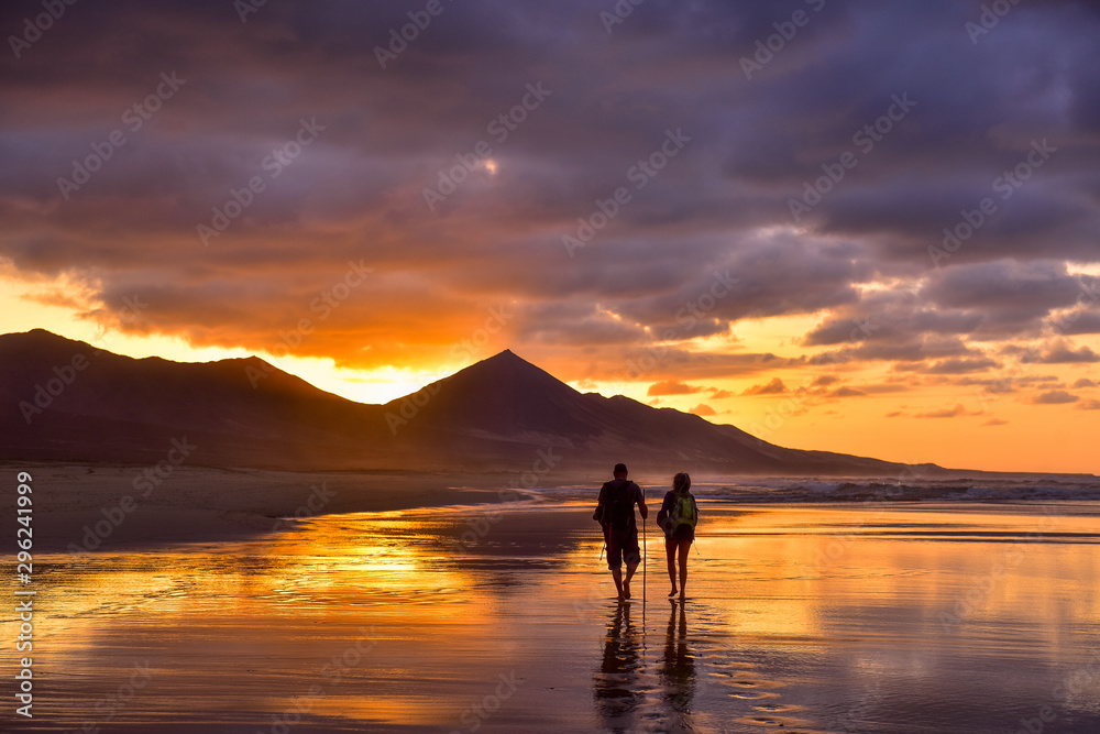 silhouettes of people walking on the beach at sunset silhouettes of people walking on the beach at sunset