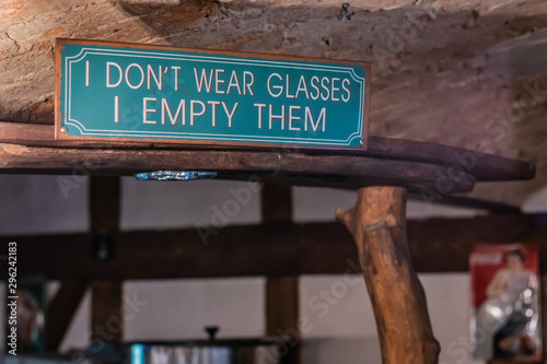 Funny inscription above the bar on a metal sign made of sheet painted green.