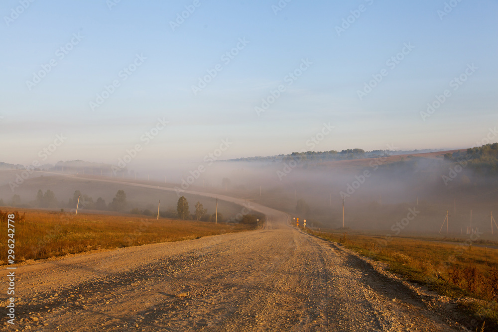 dirt road at dawn. Fog on the road