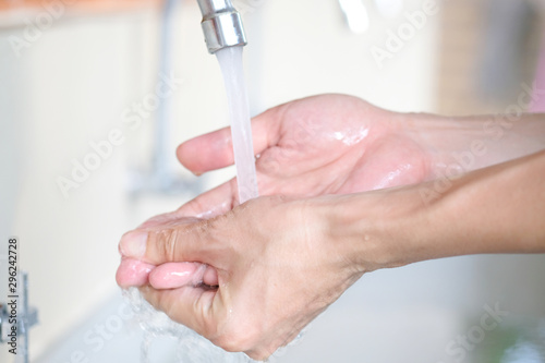 hand of beauty woman wash your hands at the wash basin with foam, cleanse the skin and have water flowing through the hands. Health and beauty concepts