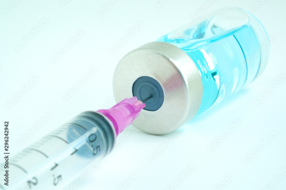 doctor's hand holds a syringe and a blue vaccine bottle at the hospital. Health and medical concepts doctor's hand holds a syringe and a blue vaccine bottle at the hospital. Health and medical concepts