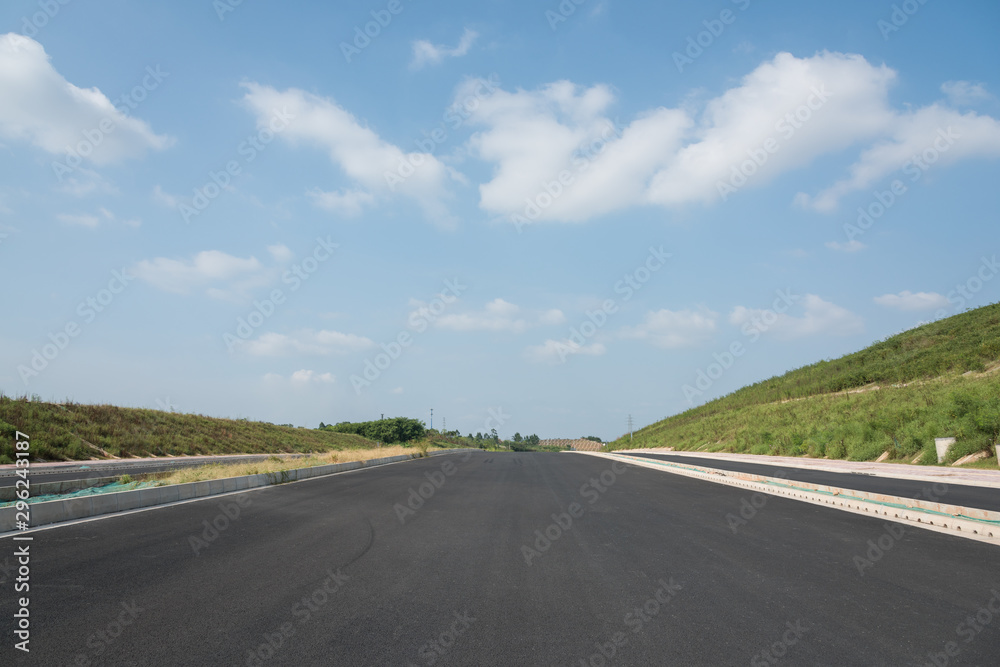 Perspective view of new asphalt road and sky in modern city suburb