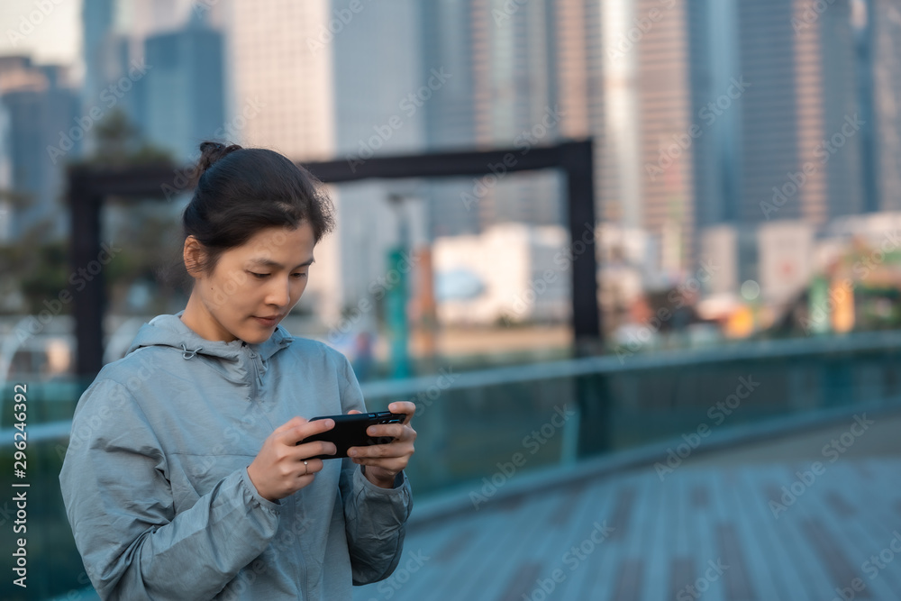 Fototapeta premium Woman playing mobile game outdoor