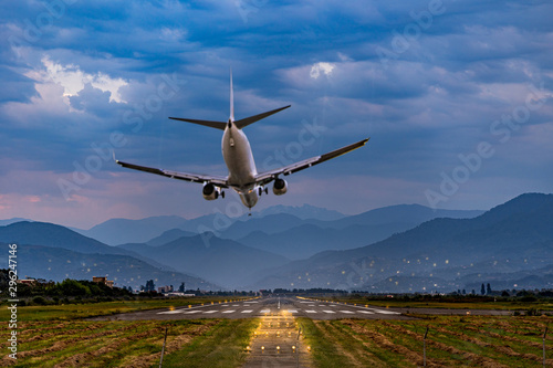 Принти на полотні Passenger air plane lands on the runway at the airport against the backdrop of t
