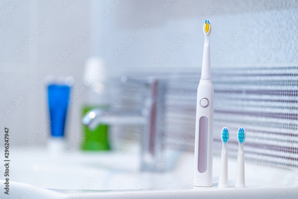 Ultrasonic electric toothbrush with interchangeable nozzles in bathroom at home. Oral hygiene, dental and gum health, healthy teeth. Dental products