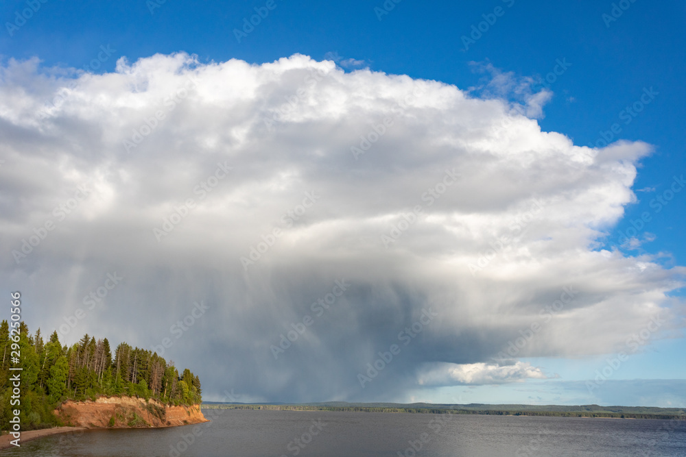 Summer landscape with a river, blue sky and cloud. Before a thunderstorm with rain