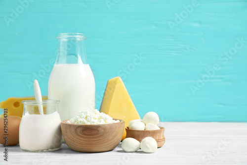 Different dairy products on white table against blue background. Space for text