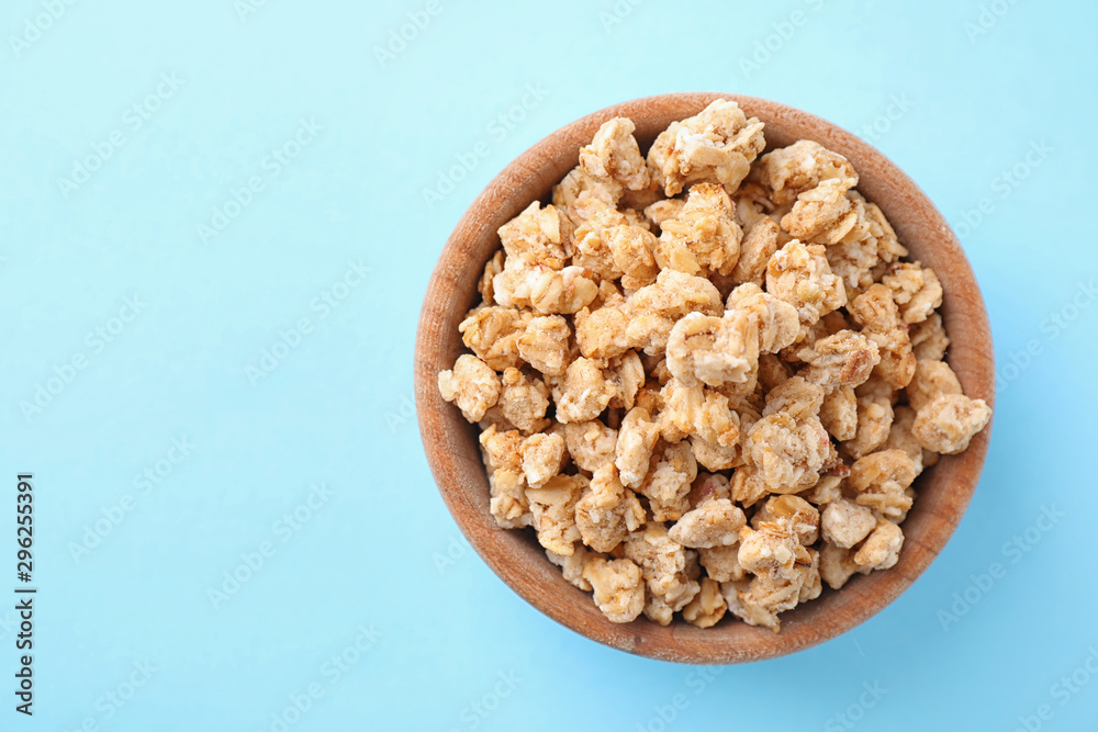 Bowl with healthy granola on light blue background, top view. Space for text Bowl with healthy granola on light blue background, top view. Space for text
